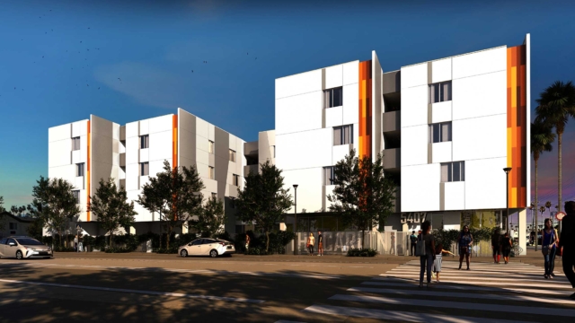 Now Leasing: The Carlton, a multifamily building with three and four levels above grade. White and orange exterior.